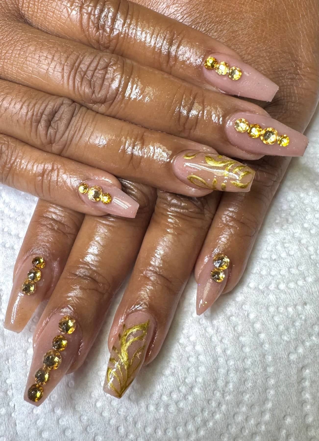 Nude nails with gold-leaf accent fingers