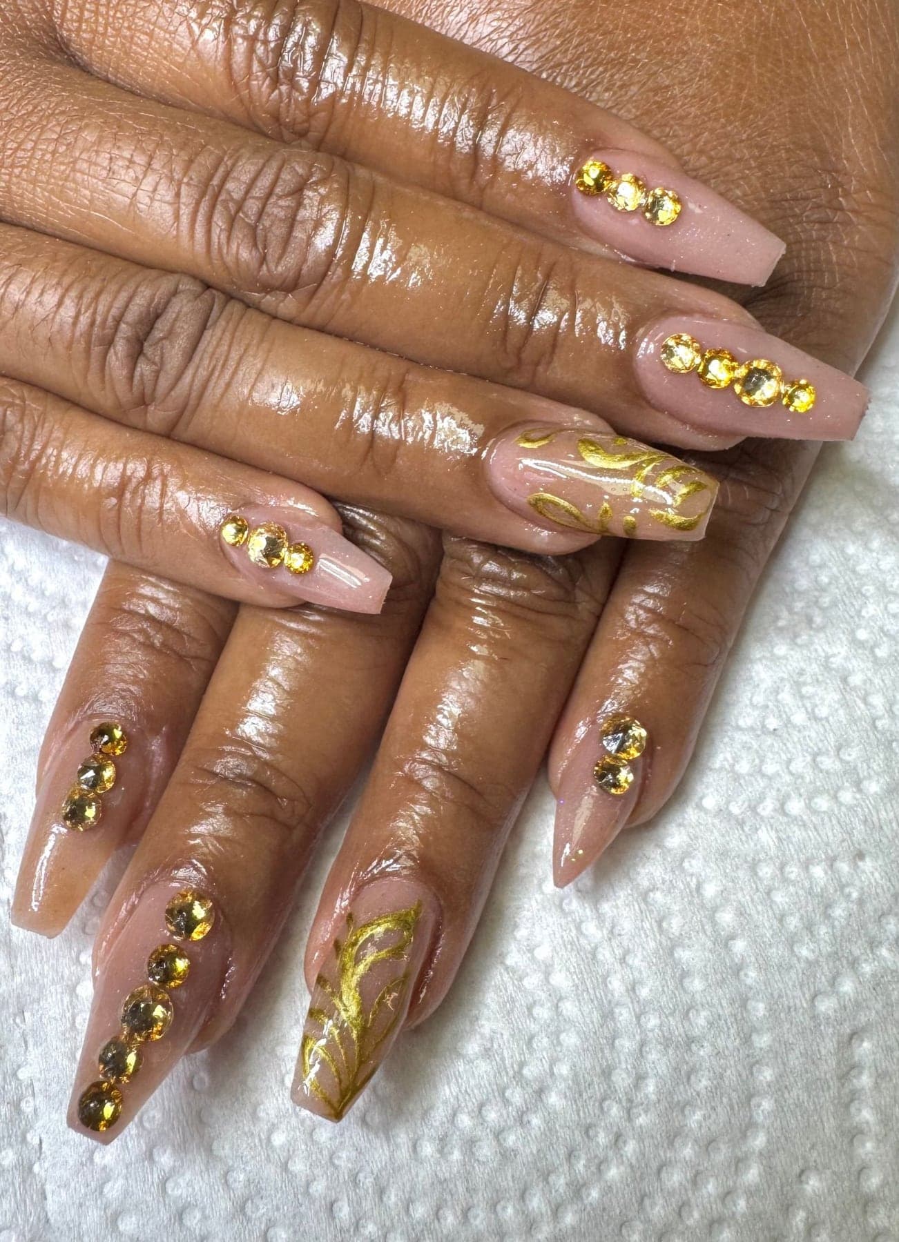 Nude nails with gold-leaf accent fingers